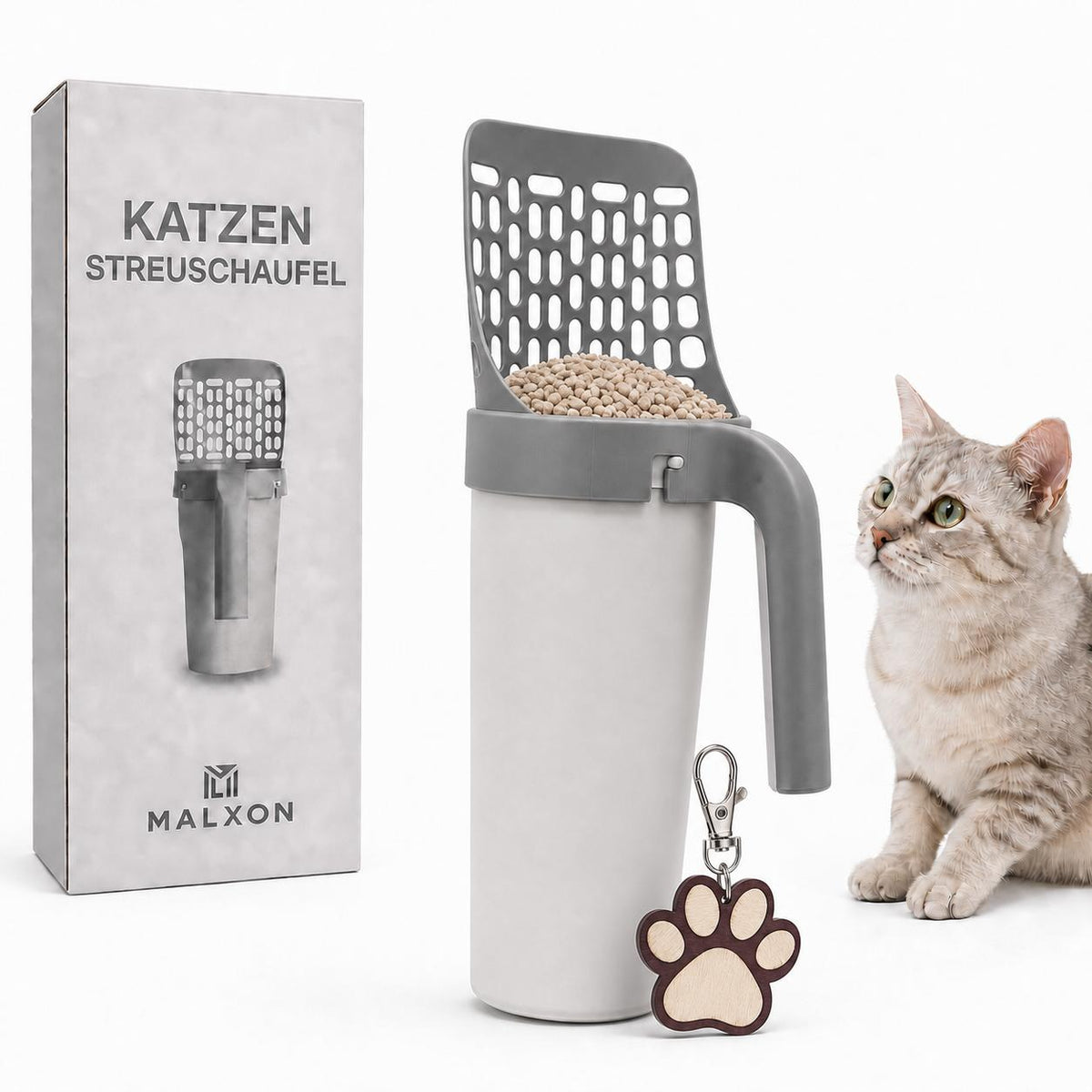 MALXON Katzenstreuschaufel mit Behälter und Verpackung, daneben sitzt eine graue Katze